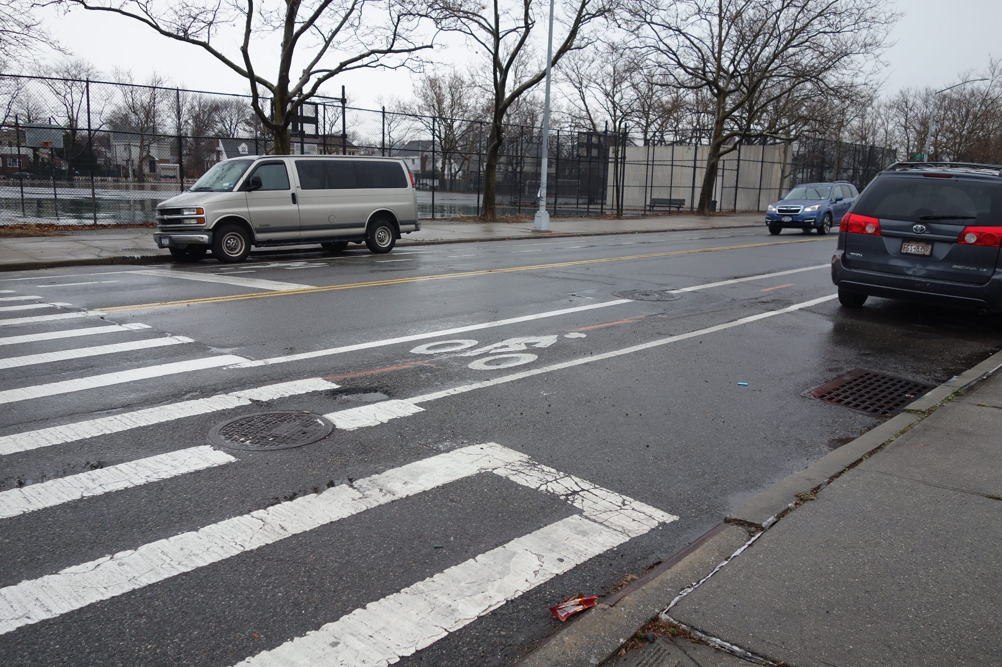 Utopia Parkway at 73rd Avenue in Queens, with a crosswalk and parked cars
